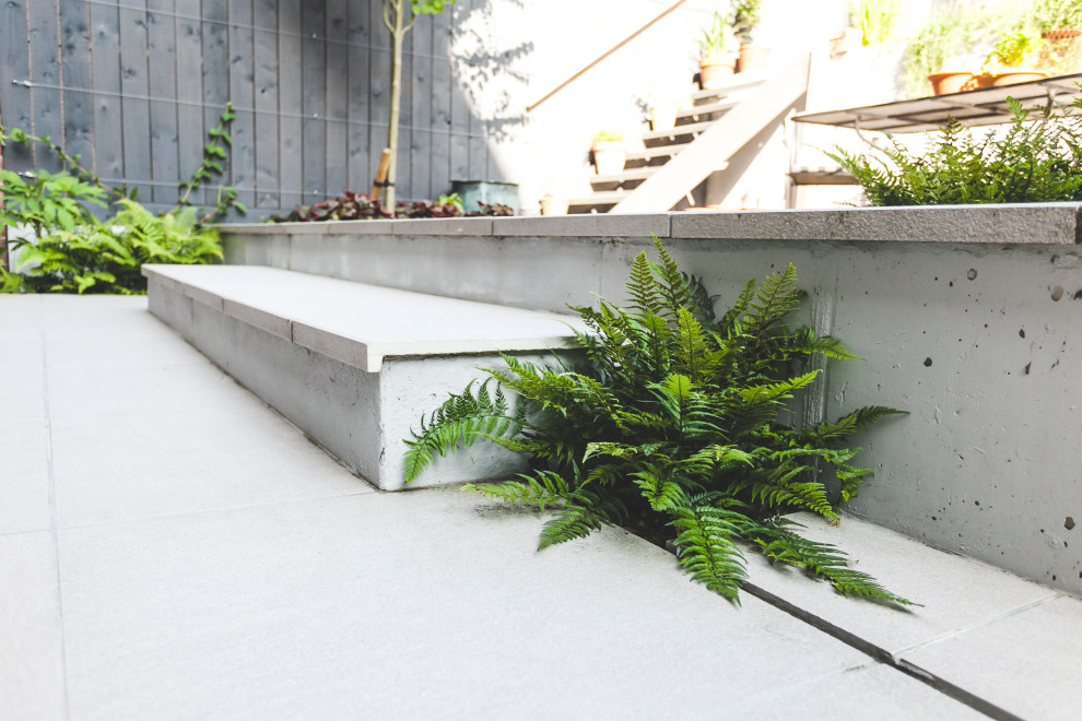 Esempio di un giardino formale contemporaneo in ombra di medie dimensioni e dietro casa in estate con un muro di contenimento e pavimentazioni in mattoni