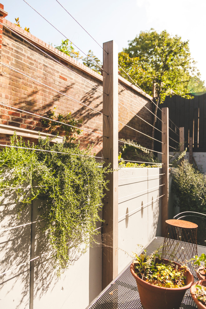 Foto di un giardino formale contemporaneo in ombra di medie dimensioni e dietro casa in estate con un muro di contenimento e pavimentazioni in mattoni