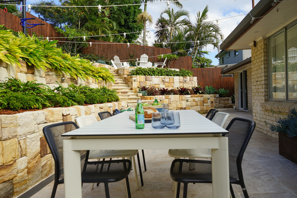 Patio - coastal backyard stone patio idea in Sydney