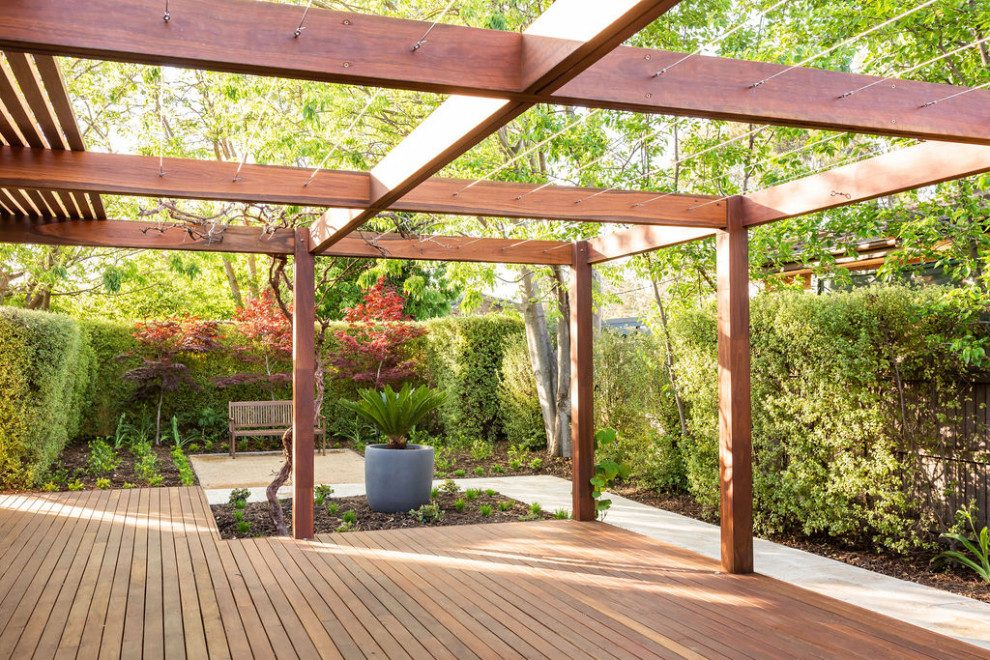 Ejemplo de jardín minimalista de tamaño medio en primavera en patio trasero con jardín francés, privacidad, exposición total al sol y entablado