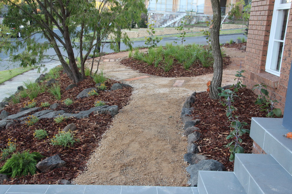 This is an example of a small traditional front full sun garden for spring in Melbourne with a garden path and gravel.