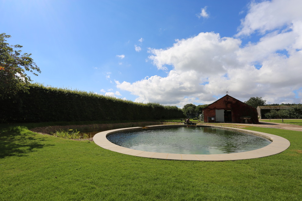 Großer Klassischer Garten im Sommer, hinter dem Haus mit Wasserspiel, direkter Sonneneinstrahlung und Natursteinplatten in Hampshire