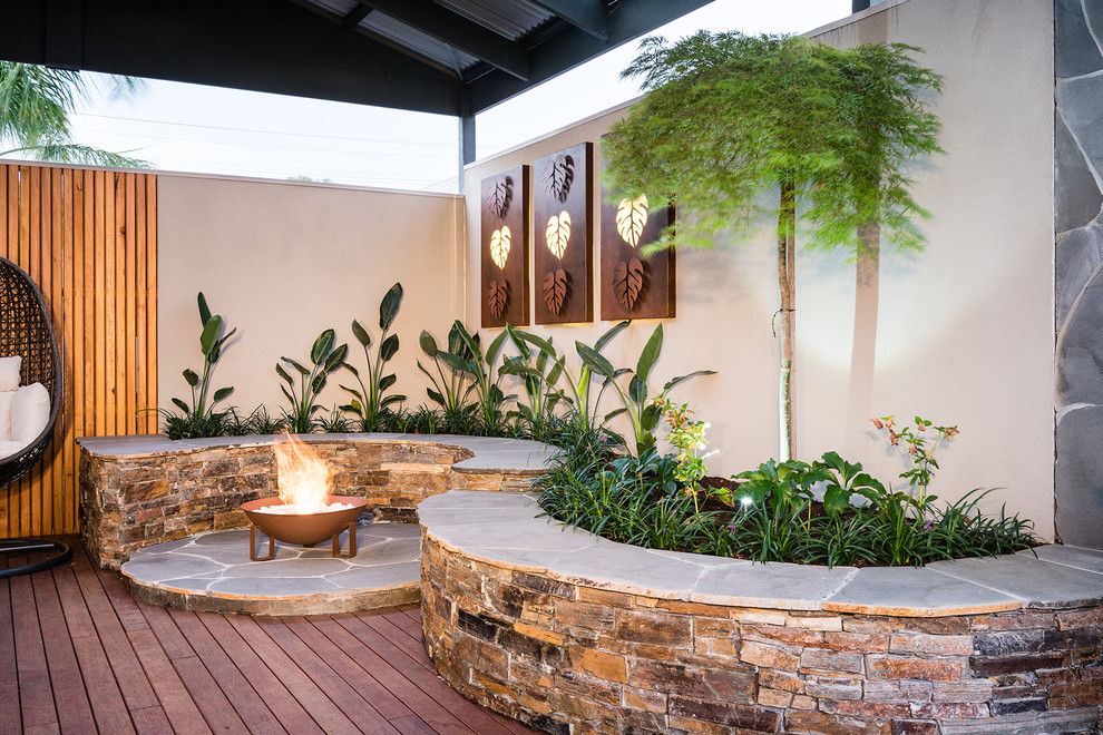 Mittelgroßer Moderner Garten hinter dem Haus mit Feuerstelle und Natursteinplatten in Melbourne