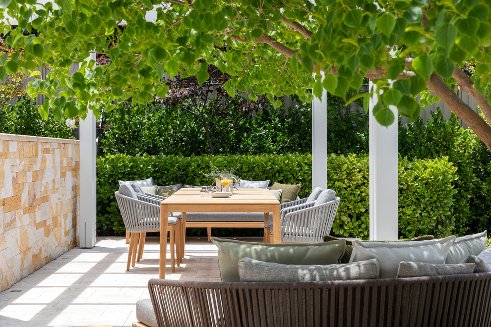 Modelo de jardín mediterráneo grande en verano en patio trasero con jardín francés, muro de contención, exposición total al sol y adoquines de piedra natural