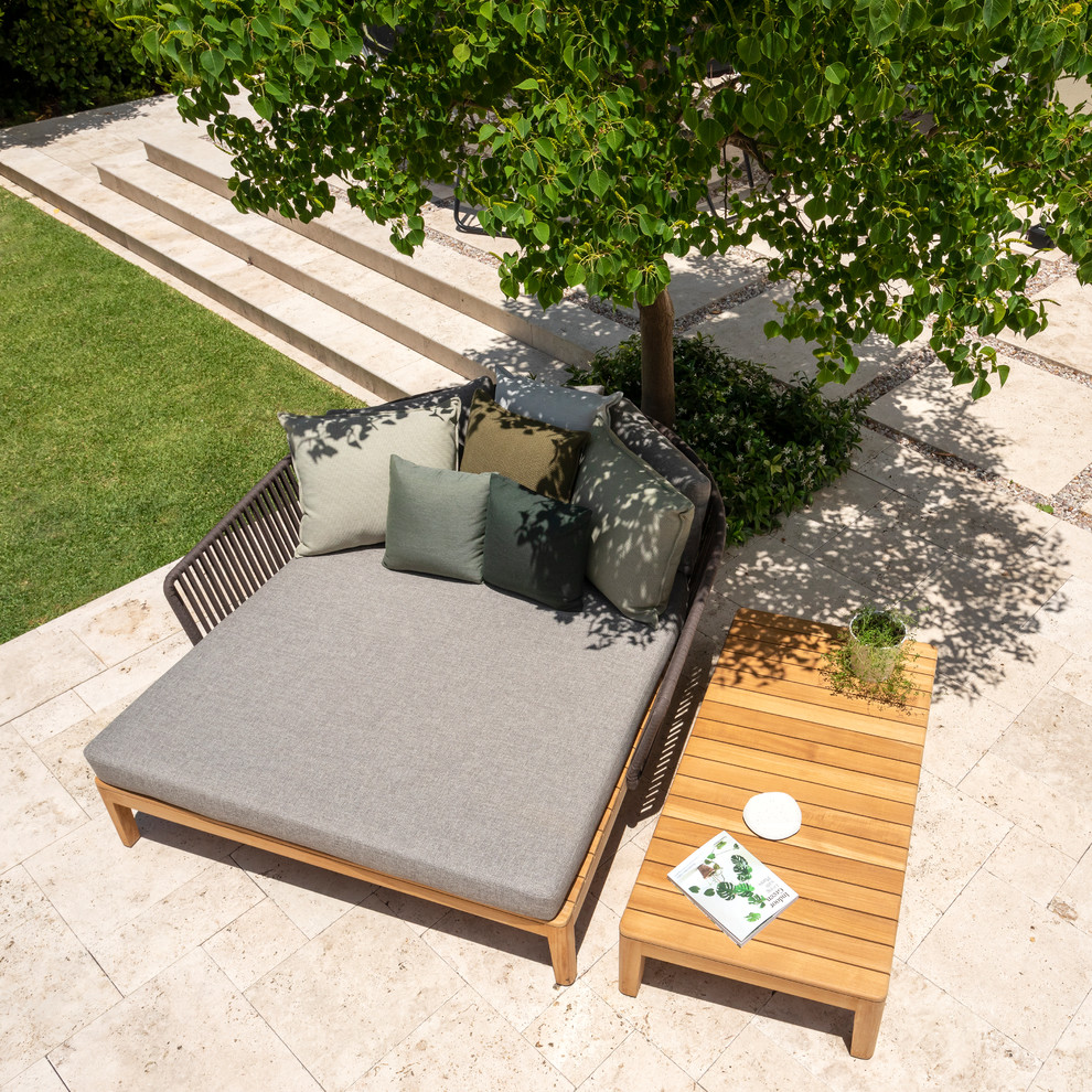 Diseño de jardín mediterráneo grande en verano en patio trasero con jardín francés, muro de contención, exposición total al sol y adoquines de piedra natural