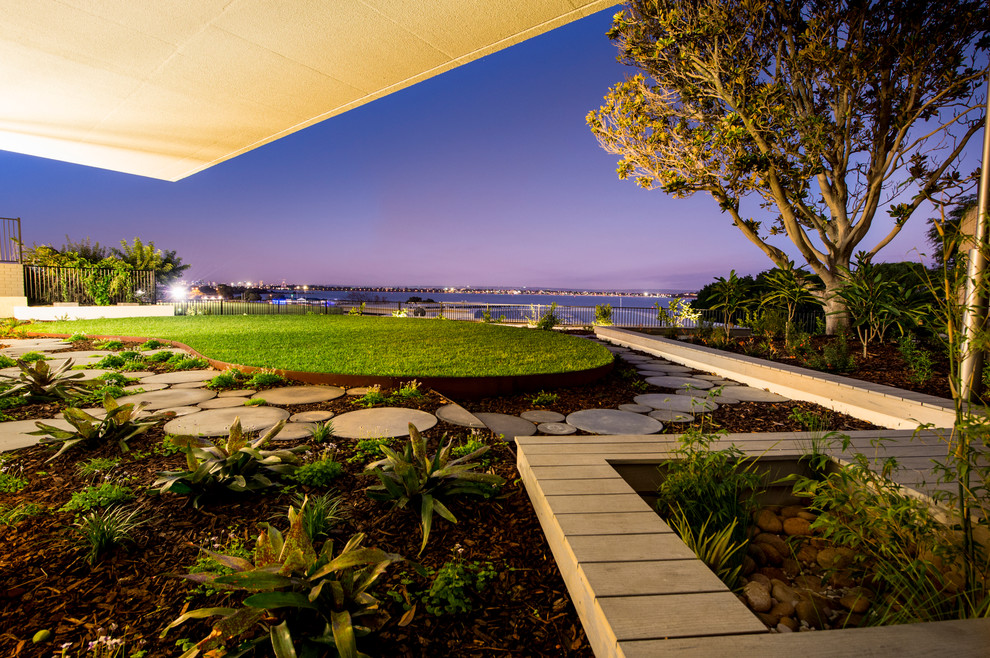 Inspiration pour un xéropaysage arrière design avec une terrasse en bois et une bordure.