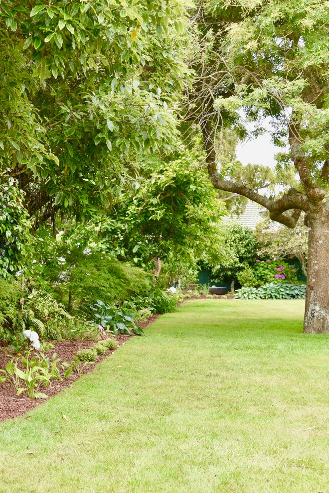 На фото: большой участок и сад на заднем дворе в классическом стиле с полуденной тенью с