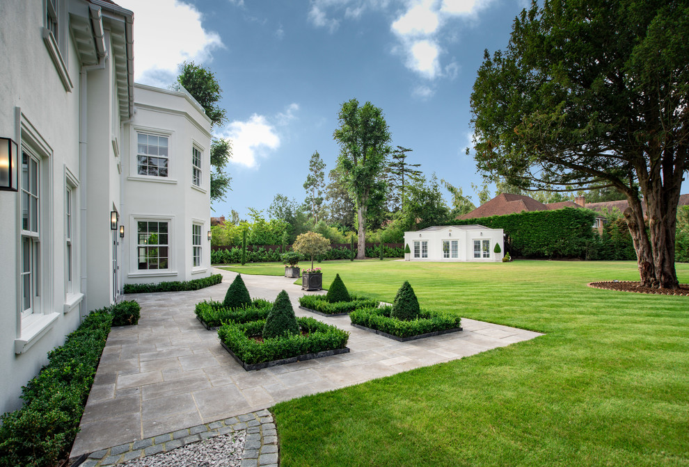 This is an example of a traditional back full sun garden in Buckinghamshire with natural stone paving.