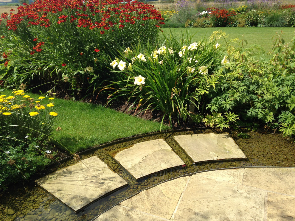 Design ideas for a huge traditional river rock landscaping in Gloucestershire.