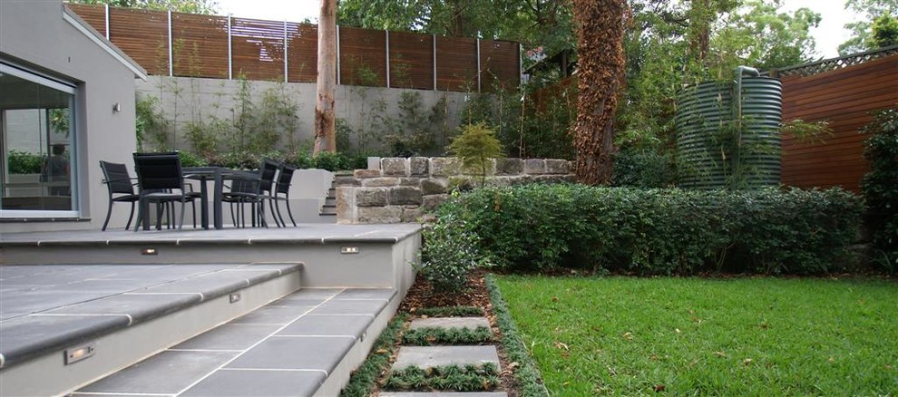 Свежая идея для дизайна: участок и сад на заднем дворе в современном стиле с мощением тротуарной плиткой - отличное фото интерьера