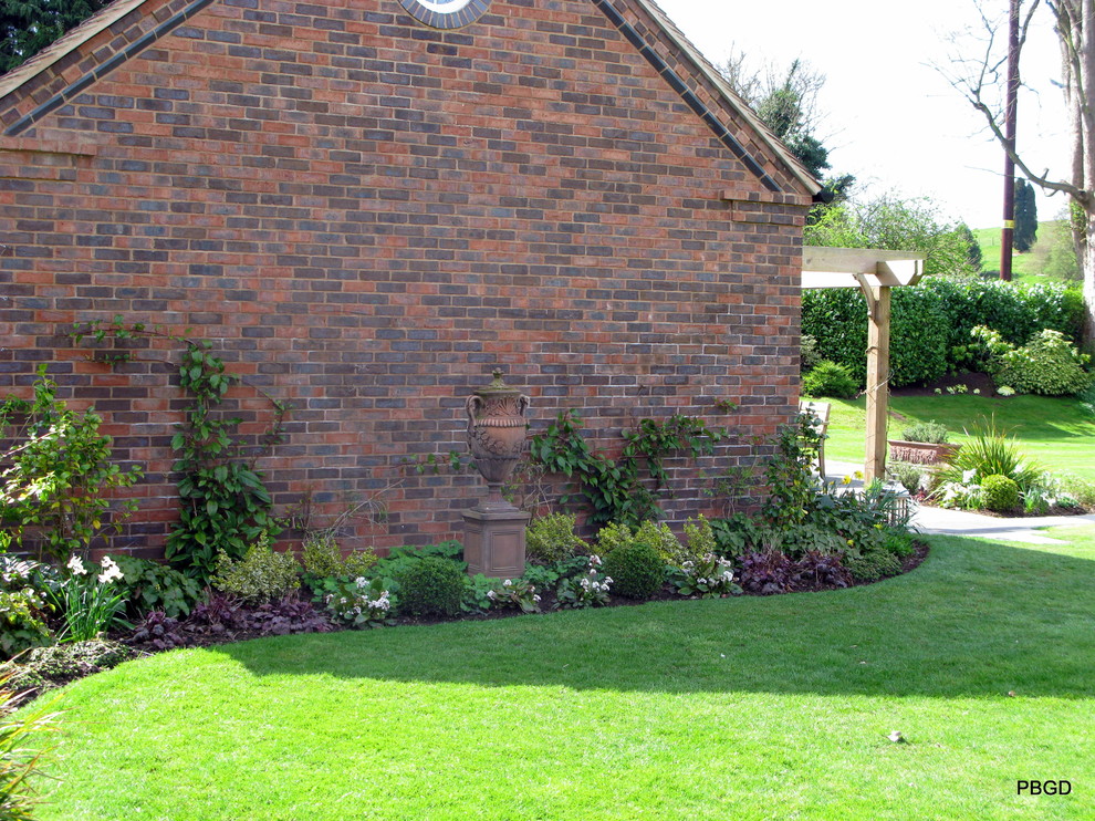 Пример оригинального дизайна: тенистый регулярный сад на боковом дворе в классическом стиле