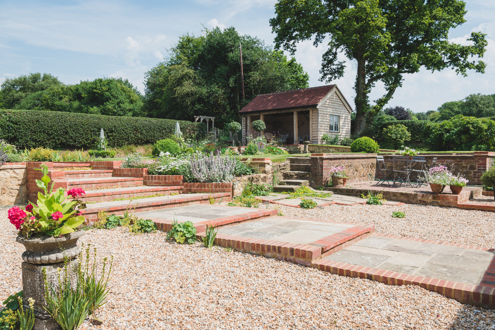 Photo of a large classic back formal garden in London with gravel.