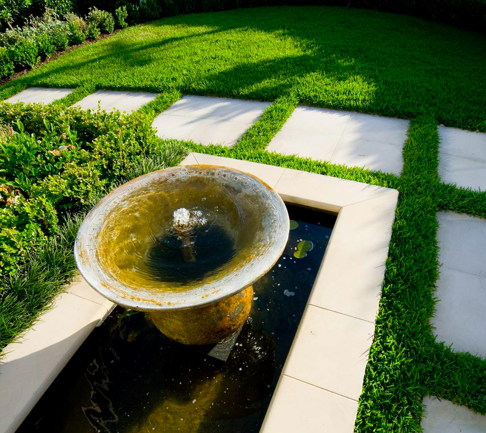 Halbschattiger Moderner Garten im Sommer, hinter dem Haus mit Wasserspiel und Natursteinplatten in Sydney