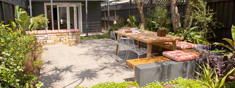 Foto de jardín minimalista de tamaño medio en verano en patio trasero con exposición total al sol, adoquines de hormigón y muro de contención