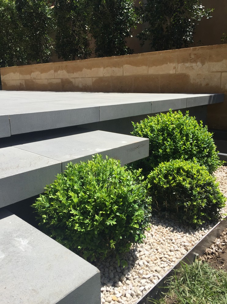 Inspiration for a mid-sized contemporary partial sun courtyard stone landscaping in Adelaide.