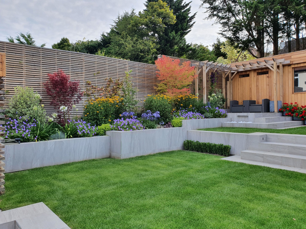 Immagine di un piccolo giardino moderno esposto in pieno sole dietro casa in estate con recinzione in legno