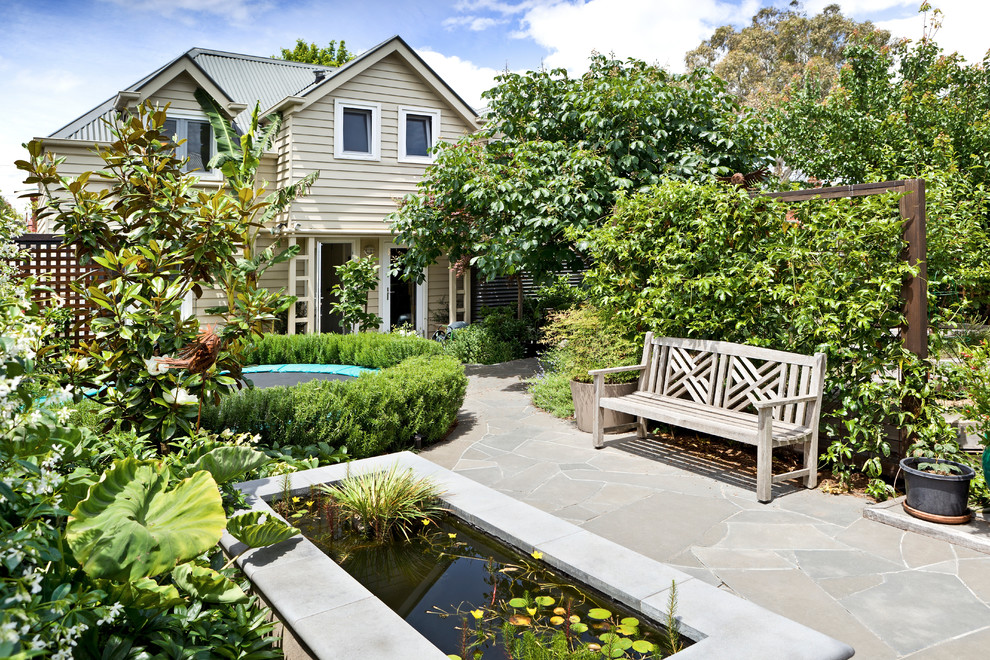 Photo of a large traditional back partial sun garden in Melbourne with a vegetable patch and natural stone paving.