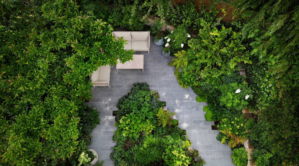 Idée de décoration pour un petit jardin arrière design l'été avec une exposition partiellement ombragée et des pavés en pierre naturelle.