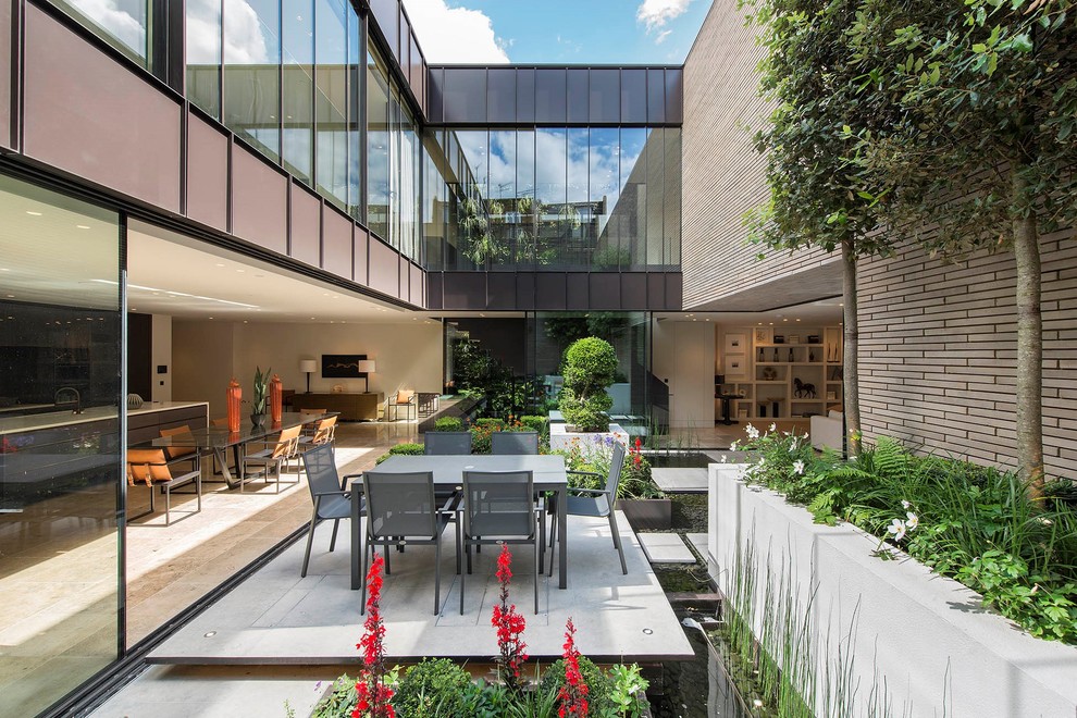 This is an example of a mid-sized contemporary courtyard pond in London.