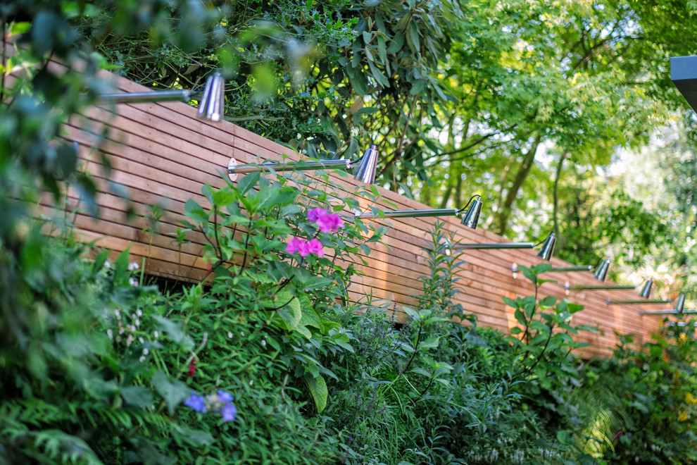 Inspiration för en stor funkis formell trädgård i delvis sol längs med huset på sommaren, med en vertikal trädgård