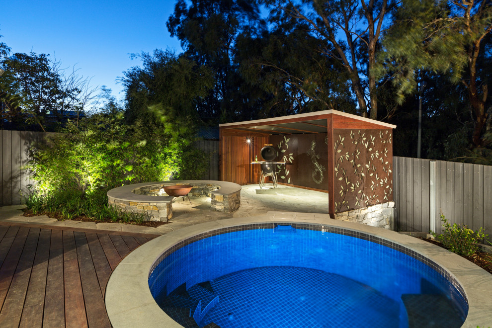 Photo of a large modern full sun backyard stone formal garden in Melbourne with a fire pit for winter.
