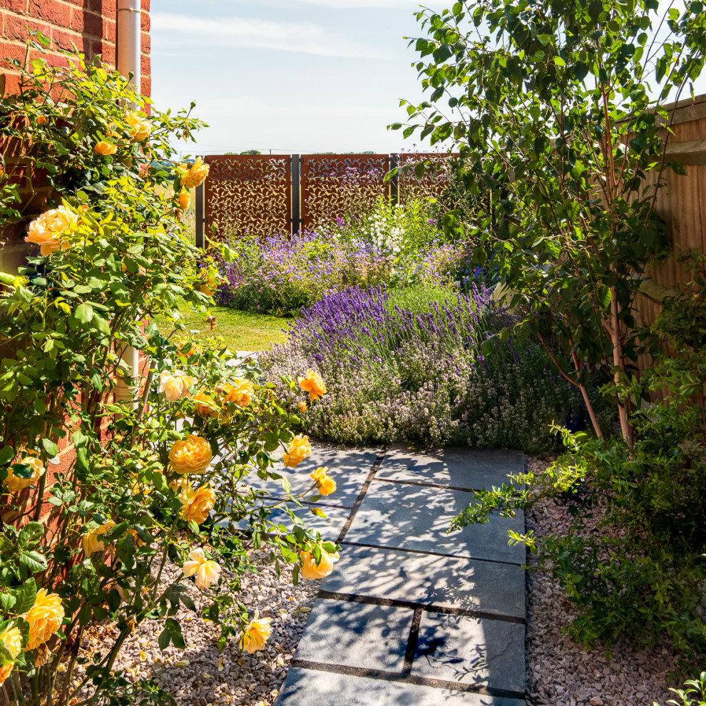 Immagine di un piccolo giardino country esposto a mezz'ombra nel cortile laterale con un ingresso o sentiero e pavimentazioni in pietra naturale