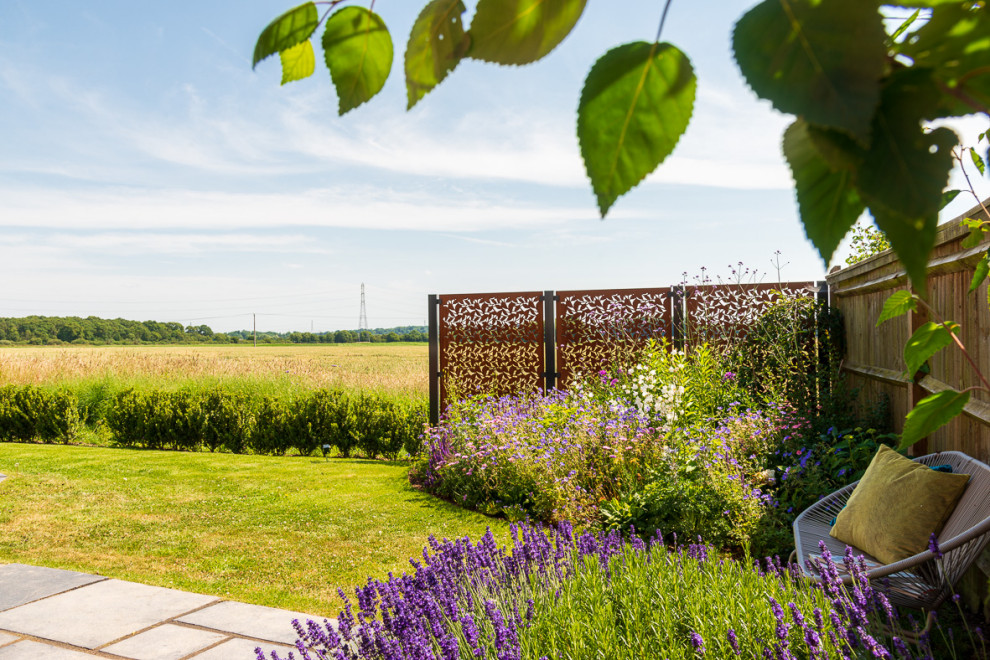 Mittelgroßer, Halbschattiger Landhaus Garten hinter dem Haus mit Blumenbeet in Hampshire