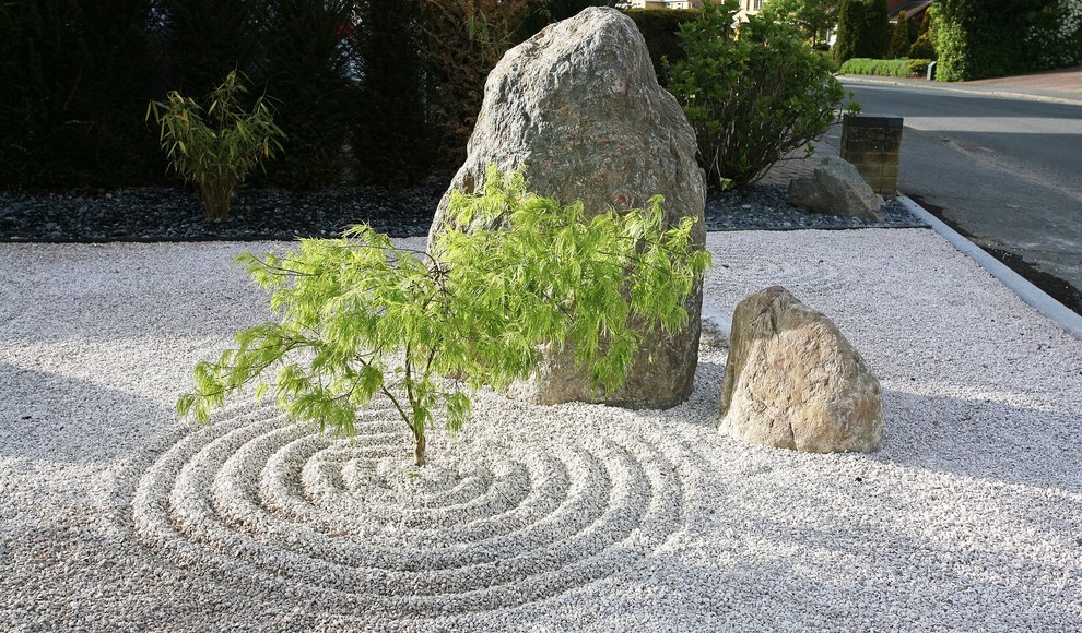 Cette image montre un jardin japonais avant asiatique de taille moyenne avec une exposition partiellement ombragée et des pavés en pierre naturelle.