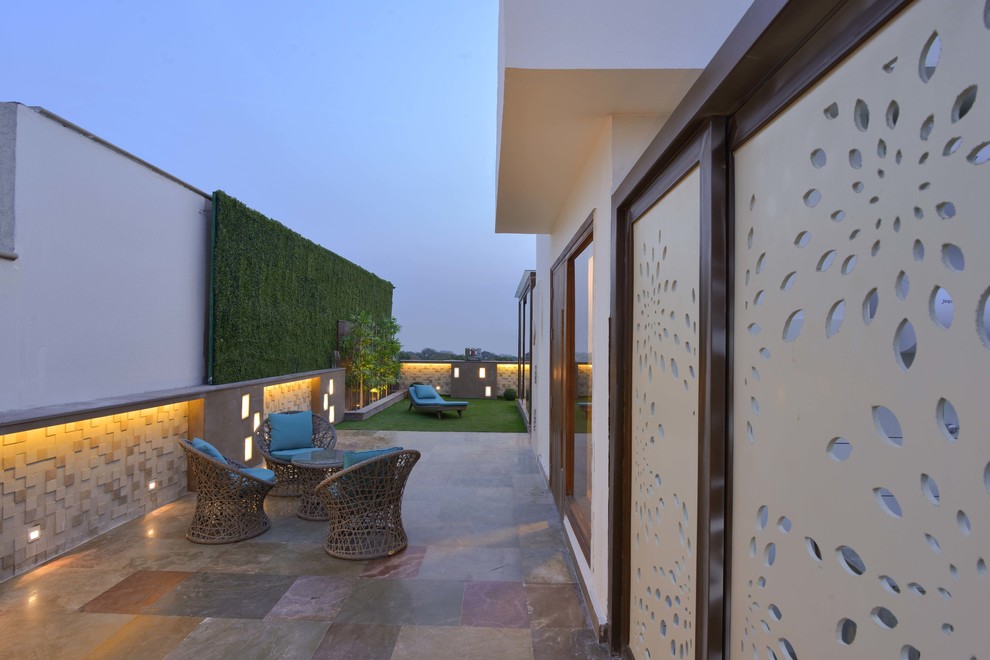Design ideas for a mid-sized contemporary partial sun rooftop concrete paver landscaping in Delhi.