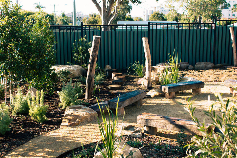 Foto di un giardino xeriscape minimal esposto in pieno sole di medie dimensioni e davanti casa con uno spazio giochi, recinzione in metallo e graniglia di granito