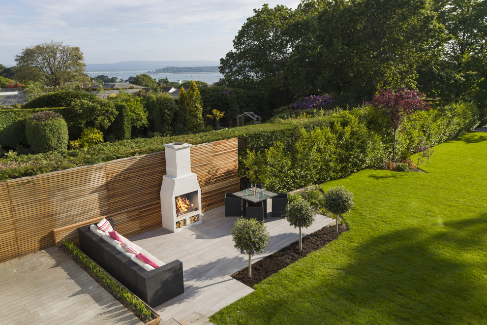 Foto di un grande giardino formale minimalista esposto in pieno sole in estate con un caminetto e pavimentazioni in cemento