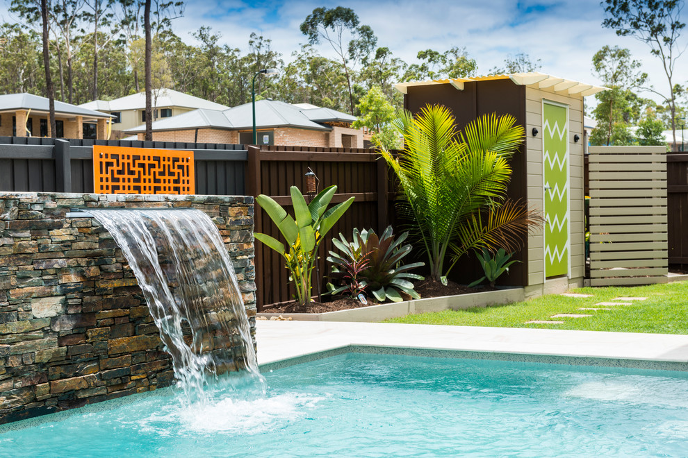 Geometrischer, Mittelgroßer Moderner Gartenwasserfall im Sommer, neben dem Haus mit Natursteinplatten in Brisbane