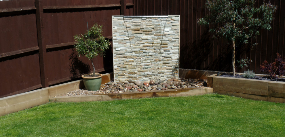 Medium sized mediterranean back partial sun garden for summer in Other with a water feature and decking.