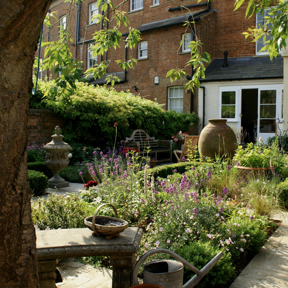Ejemplo de jardín clásico pequeño en patio con jardín francés, exposición parcial al sol y adoquines de piedra natural