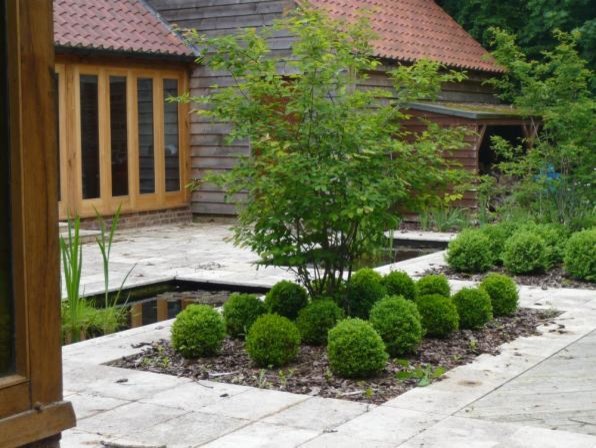 Inspiration for a medium sized contemporary back partial sun garden in London with natural stone paving.