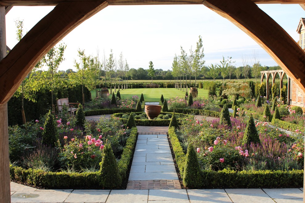 Пример оригинального дизайна: огромный солнечный, летний регулярный сад на заднем дворе в стиле кантри с садовой дорожкой или калиткой, хорошей освещенностью и покрытием из каменной брусчатки