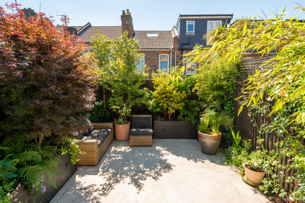Foto de jardín minimalista pequeño en patio con macetero elevado, exposición parcial al sol y adoquines de hormigón