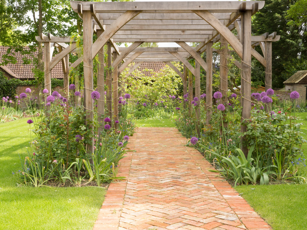 Idée de décoration pour un grand jardin avec pergola arrière champêtre avec des pavés en brique.