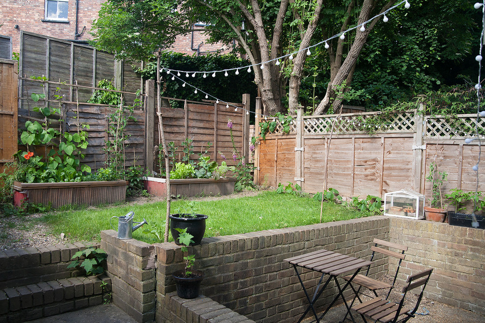 Idées déco pour un petit jardin arrière éclectique au printemps avec une exposition partiellement ombragée et des pavés en béton.