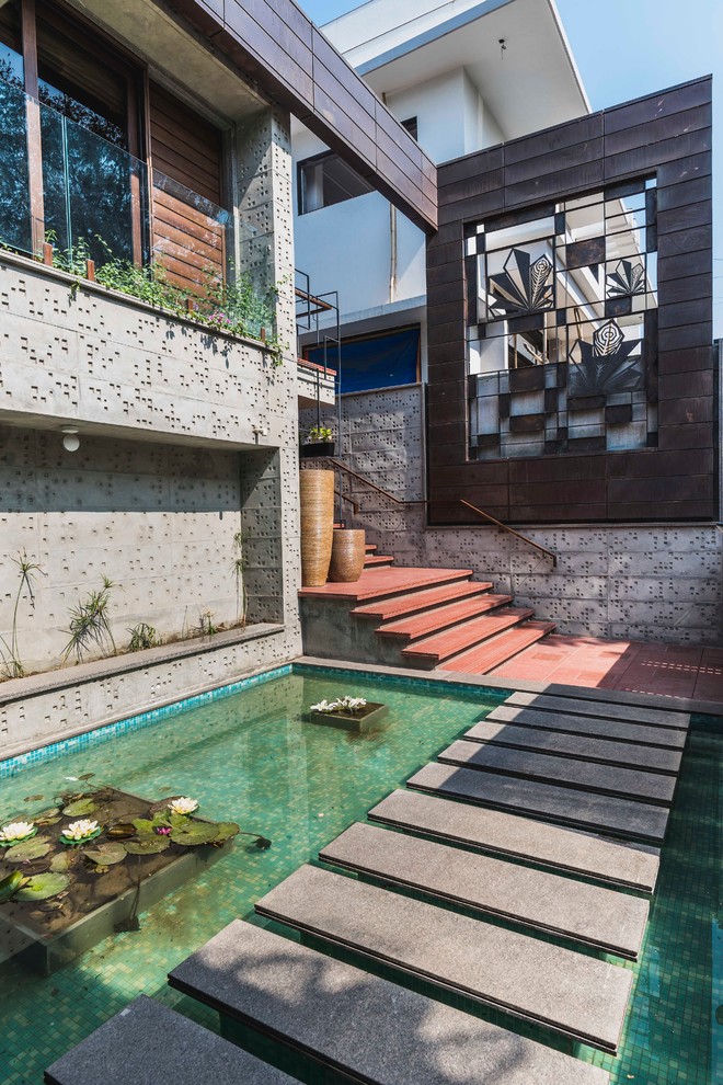 Aménagement d'un jardin asiatique avec un bassin et des pavés en béton.