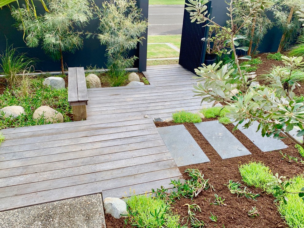 This is an example of a medium sized beach style front garden in Sunshine Coast with a garden path and decking.