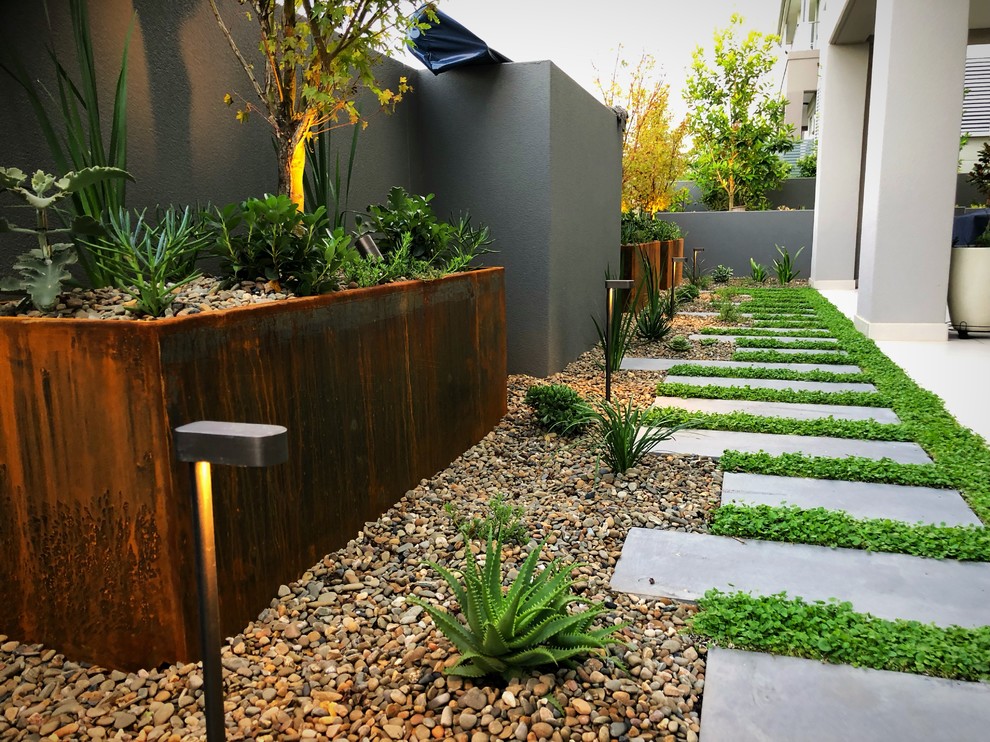 На фото: регулярный сад среднего размера на внутреннем дворе в современном стиле с садовой дорожкой или калиткой, полуденной тенью и мощением тротуарной плиткой с