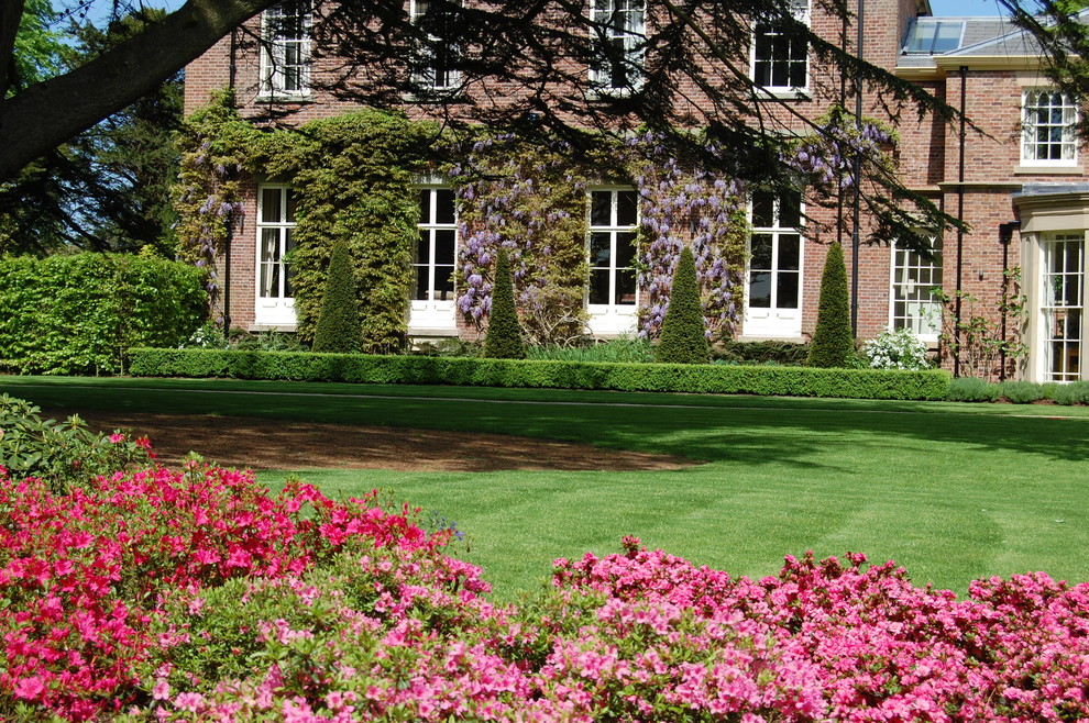 Geometrischer Klassischer Garten hinter dem Haus mit Natursteinplatten in Cheshire