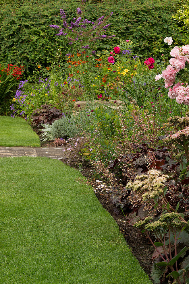This is an example of a traditional partial sun formal garden in Other for summer.