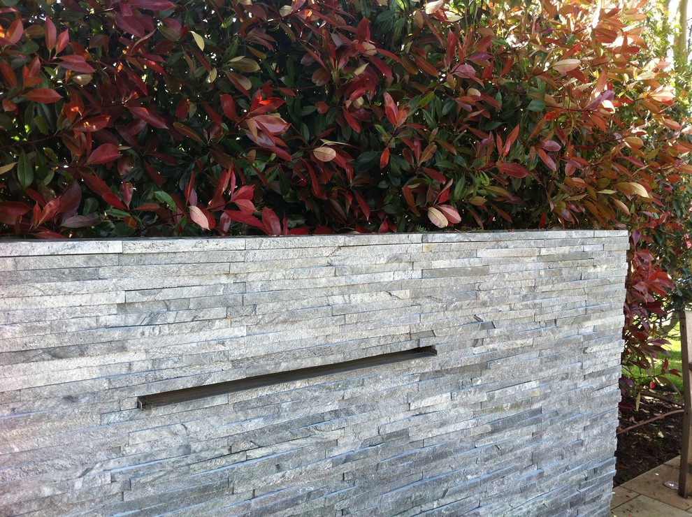 Inspiration for a large contemporary back partial sun garden in London with a water feature.