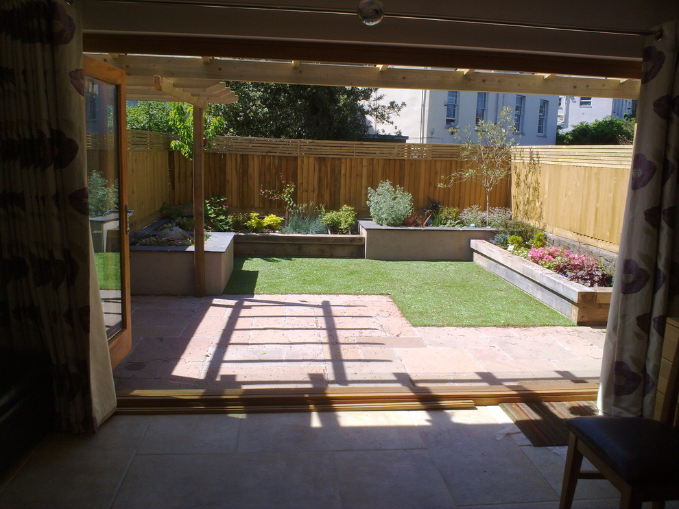 Foto de jardín moderno con muro de contención y adoquines de ladrillo