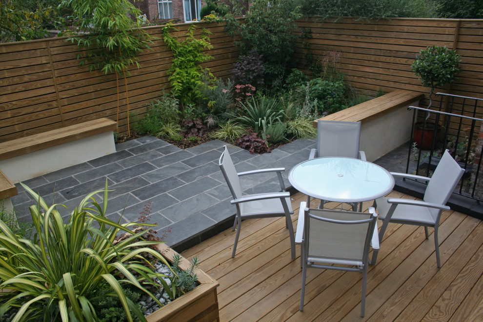Foto di un piccolo giardino minimal esposto in pieno sole dietro casa con un focolare e pavimentazioni in pietra naturale