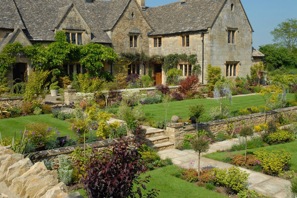 Immagine di un ampio giardino chic esposto in pieno sole davanti casa con pavimentazioni in pietra naturale