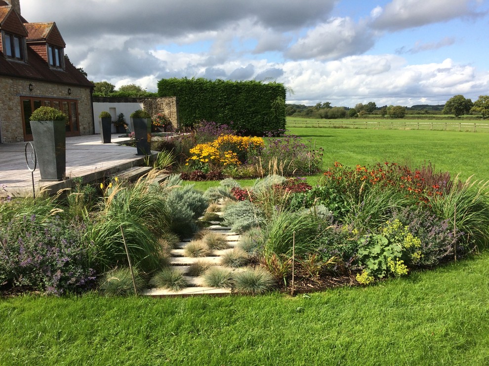 Idee per un grande giardino country esposto in pieno sole dietro casa in estate con pavimentazioni in pietra naturale