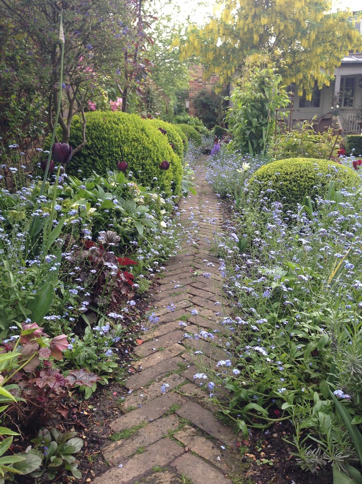 Immagine di un giardino formale chic esposto a mezz'ombra di medie dimensioni e dietro casa in primavera con pavimentazioni in mattoni